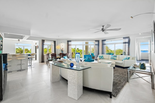 living area with light tile patterned floors and a ceiling fan