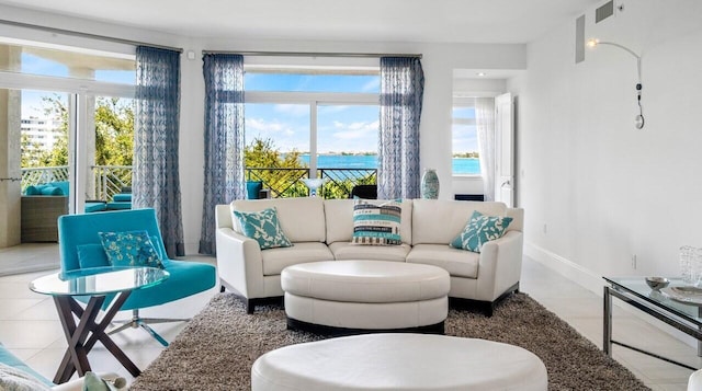 living room with a water view and tile patterned floors