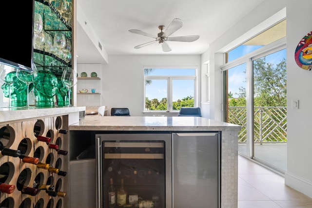 interior space with ceiling fan, beverage cooler, light tile patterned floors, and a healthy amount of sunlight