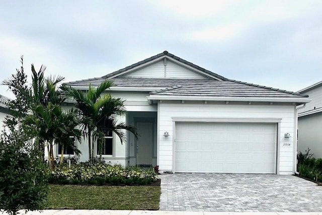 ranch-style house featuring a garage and decorative driveway