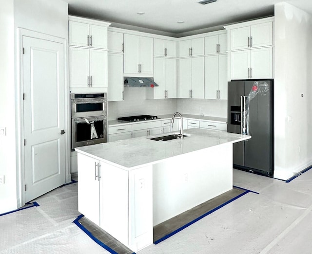 kitchen featuring stainless steel appliances, an island with sink, white cabinets, and sink