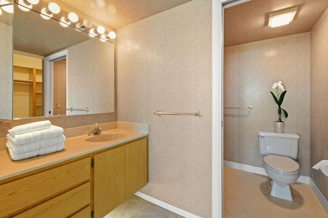 bathroom with tile patterned flooring, vanity, and toilet