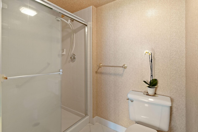 bathroom featuring toilet and a shower with shower door