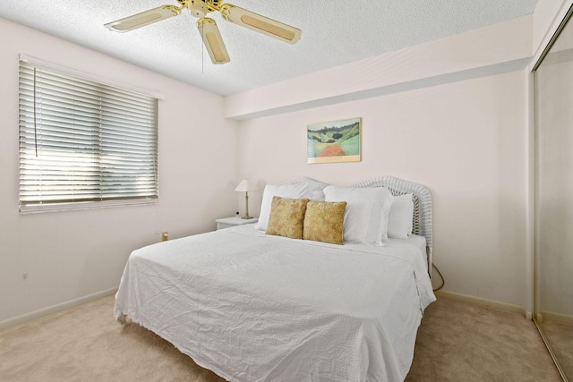 carpeted bedroom with ceiling fan, a closet, and a textured ceiling