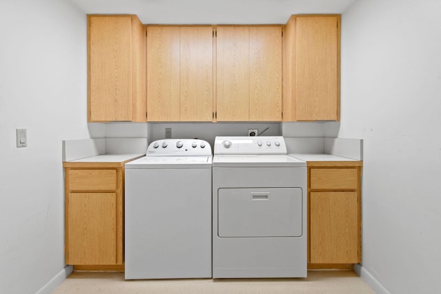 washroom with cabinets and washing machine and clothes dryer