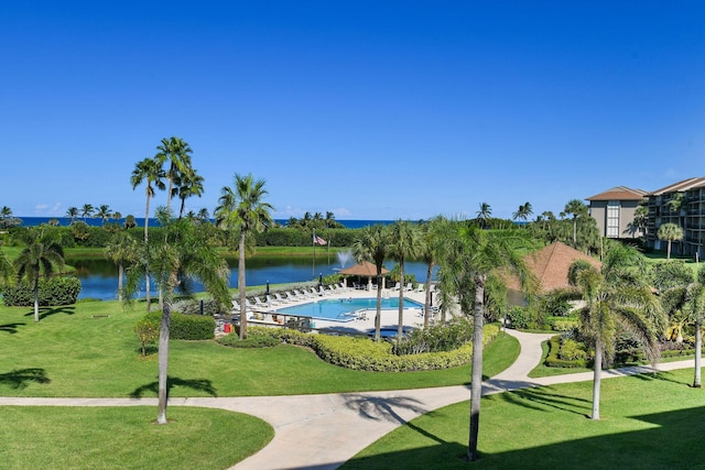 view of home's community featuring a pool, a yard, and a water view