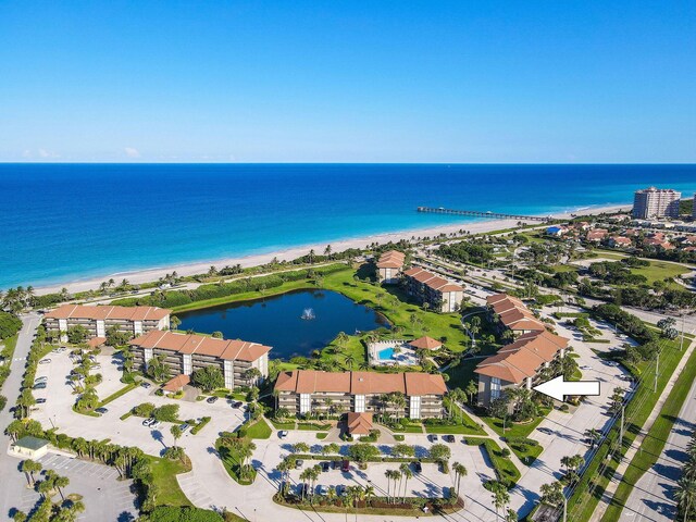 drone / aerial view featuring a water view and a view of the beach