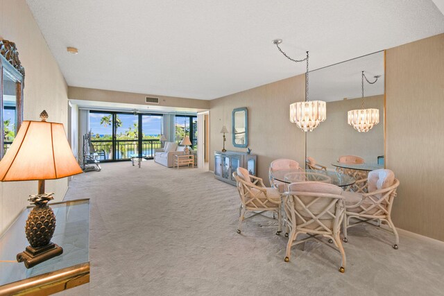 dining area with a textured ceiling and light carpet