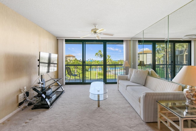 living room featuring ceiling fan, floor to ceiling windows, light colored carpet, and a textured ceiling