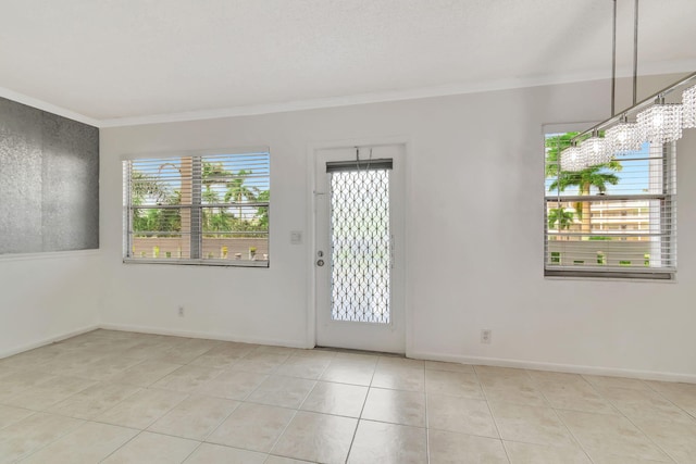 empty room with light tile patterned flooring, a healthy amount of sunlight, and ornamental molding