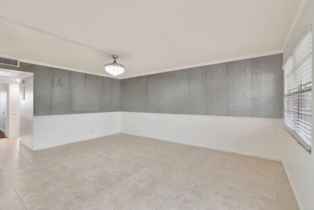 spare room featuring light tile patterned floors and ornamental molding