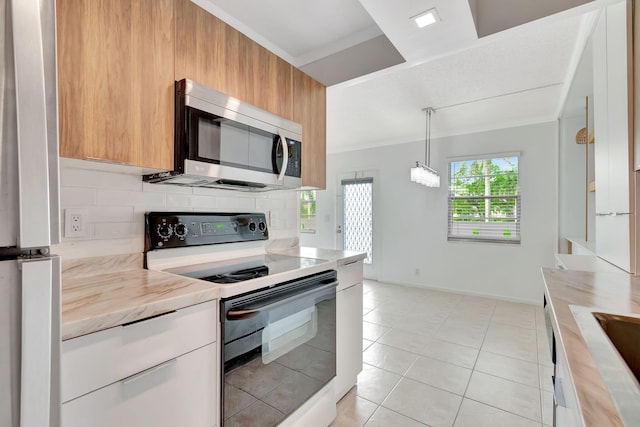 kitchen featuring butcher block counters, hanging light fixtures, stainless steel appliances, backsplash, and light tile patterned floors