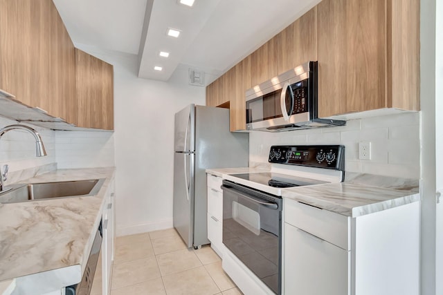 kitchen with decorative backsplash, appliances with stainless steel finishes, sink, white cabinets, and light tile patterned flooring