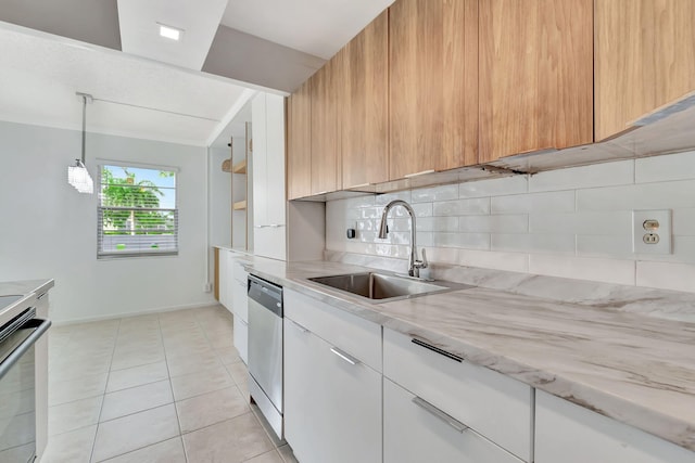 kitchen featuring appliances with stainless steel finishes, backsplash, sink, white cabinets, and light tile patterned flooring