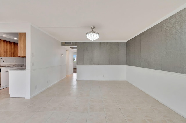 tiled spare room featuring ornamental molding and sink