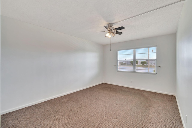 carpeted spare room featuring ceiling fan and a textured ceiling