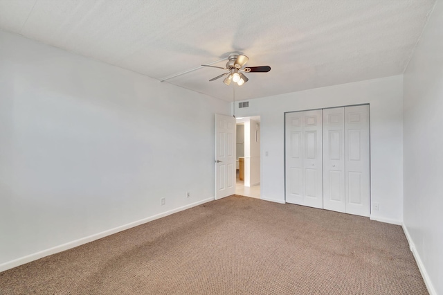 unfurnished bedroom with ceiling fan, a closet, carpet, and a textured ceiling