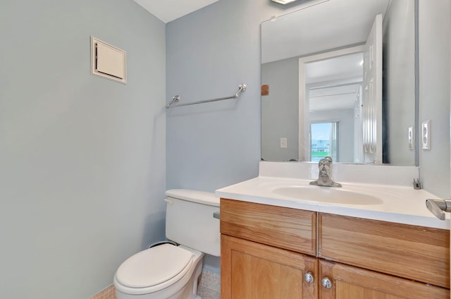 bathroom with tile patterned flooring, vanity, and toilet