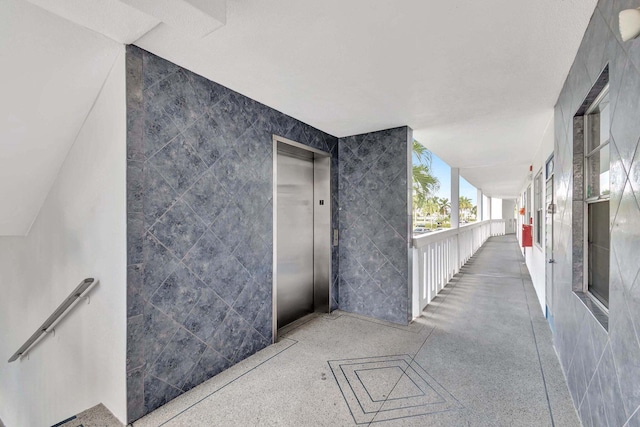 interior space with tile walls and elevator