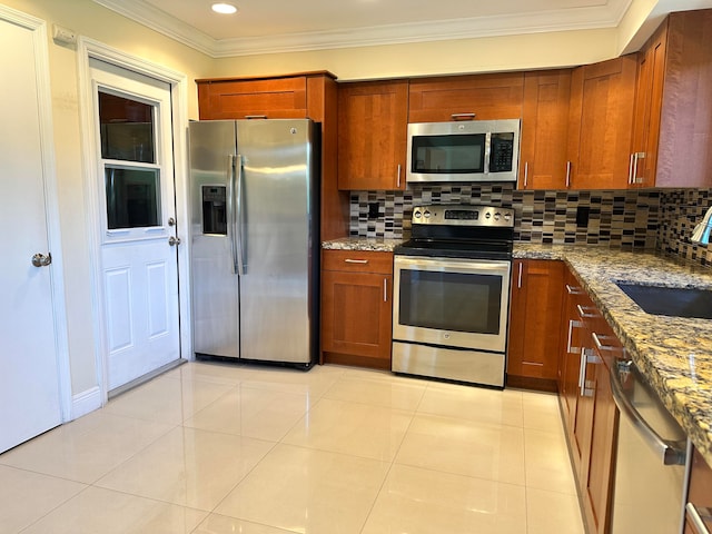 kitchen featuring light stone countertops, appliances with stainless steel finishes, sink, and tasteful backsplash