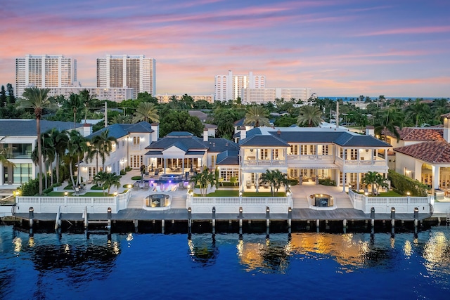 aerial view at dusk featuring a water view