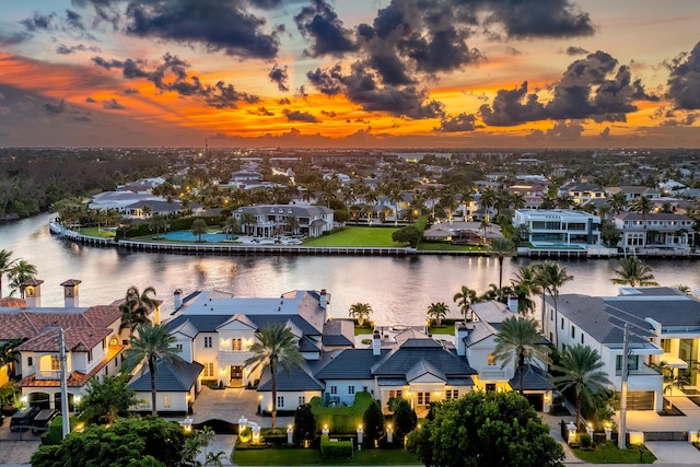 aerial view at dusk featuring a water view