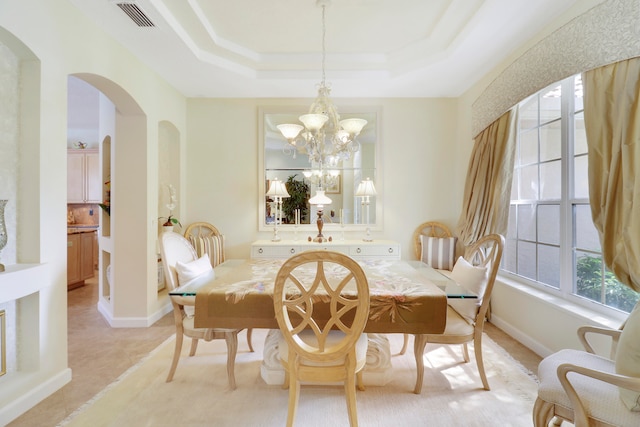 dining room with a tray ceiling and a chandelier