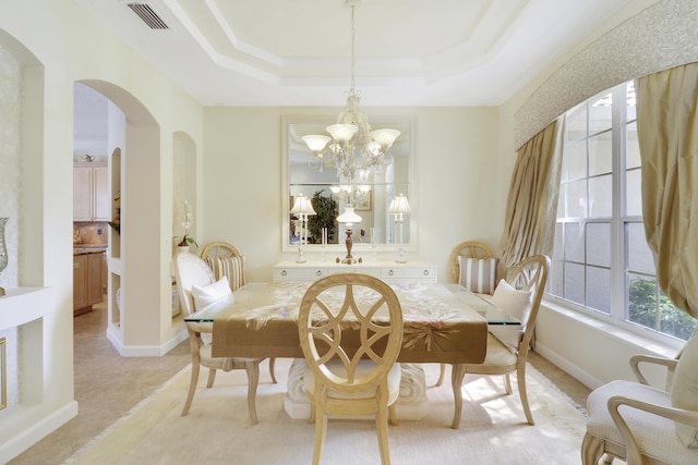 8100 Alister Pl, Port Saint Lucie, FL 34986 - dining area featuring arched walkways, a chandelier, a raised ceiling, and ornamental molding
