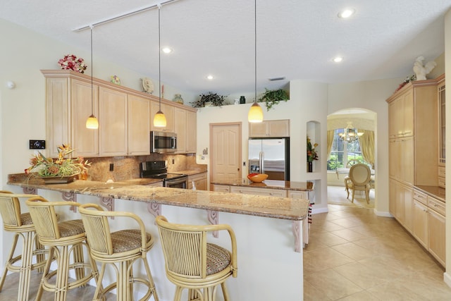 8100 Alister Pl, Port Saint Lucie, FL 34986 - kitchen featuring appliances with stainless steel finishes, recessed lighting, tasteful backsplash, a peninsula, and arched walkways