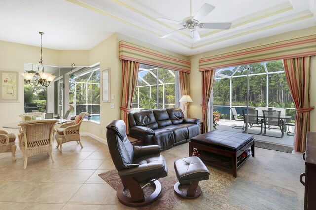 8100 Alister Pl, Port Saint Lucie, FL 34986 - living room with a chandelier, ceiling fan, light tile patterned floors, a tray ceiling, and baseboards