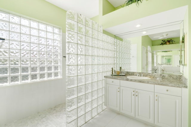 bathroom featuring a shower, tile walls, vanity, ceiling fan, and tile patterned floors