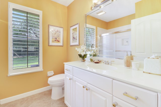 bathroom with tile patterned flooring, a shower with shower door, vanity, and toilet