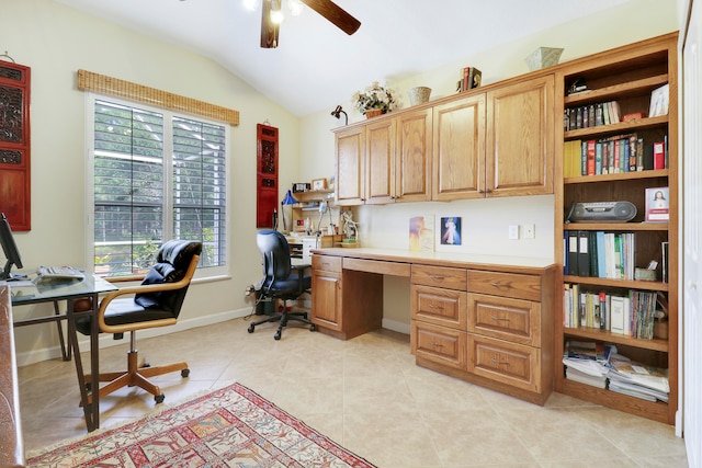office with built in desk, light tile patterned floors, vaulted ceiling, and ceiling fan