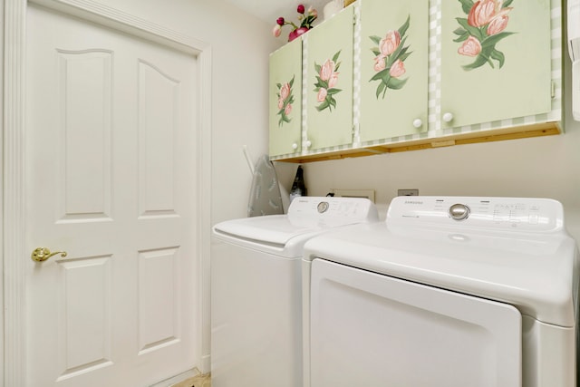 laundry room featuring separate washer and dryer and cabinets