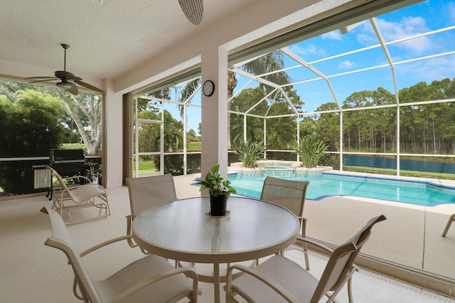 view of pool with ceiling fan, glass enclosure, and a patio area
