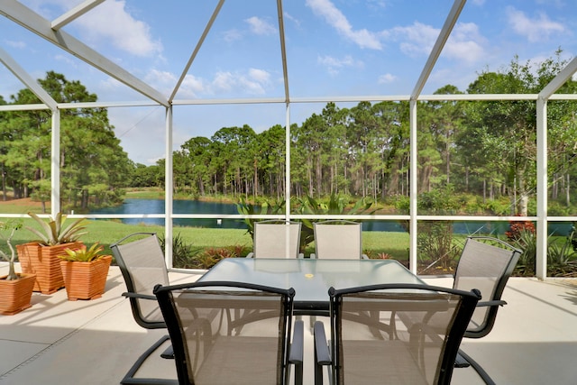 view of patio featuring a water view and glass enclosure