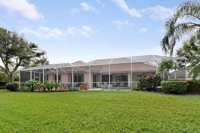 rear view of house featuring a lanai and a lawn