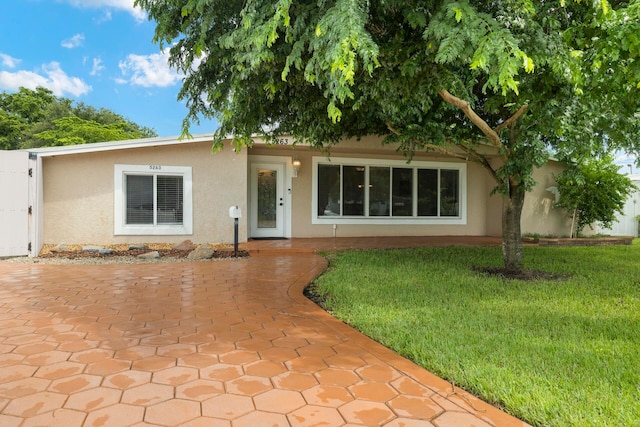 ranch-style home with a front lawn