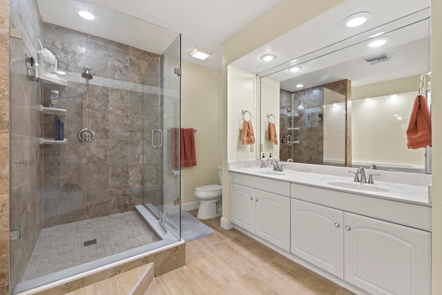 bathroom with vanity, a shower with shower door, toilet, and tile patterned flooring