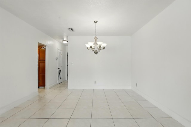 unfurnished room with baseboards, a notable chandelier, visible vents, and light tile patterned floors