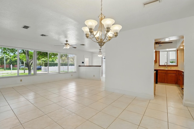 spare room with light tile patterned floors, a sink, visible vents, and ceiling fan with notable chandelier