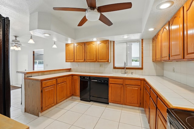 kitchen with a peninsula, dishwasher, a ceiling fan, and a sink