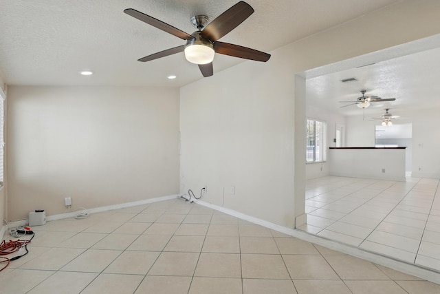 unfurnished room featuring tile patterned floors, a ceiling fan, and a textured ceiling