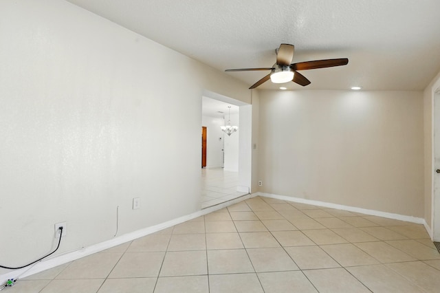 spare room with a textured ceiling, baseboards, recessed lighting, ceiling fan with notable chandelier, and light tile patterned floors