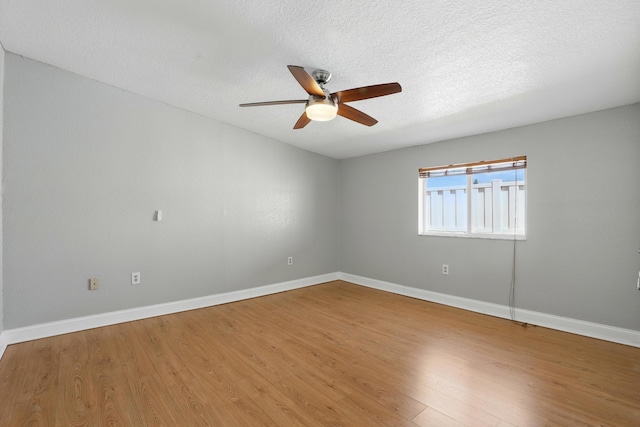 empty room with baseboards, a ceiling fan, and wood finished floors