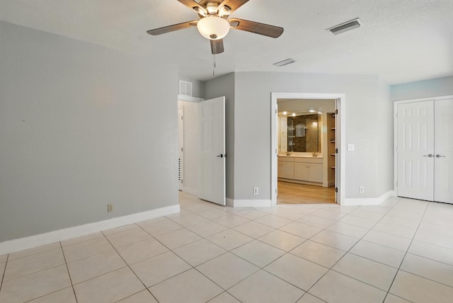 unfurnished bedroom with baseboards, visible vents, a closet, and light tile patterned flooring