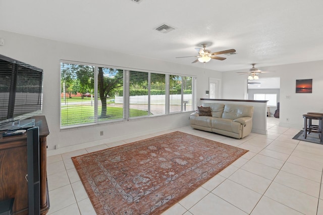 tiled living room with ceiling fan and plenty of natural light