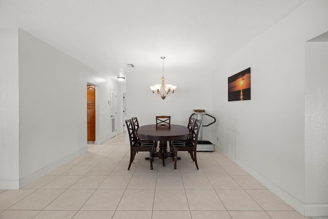 tiled dining room with a notable chandelier