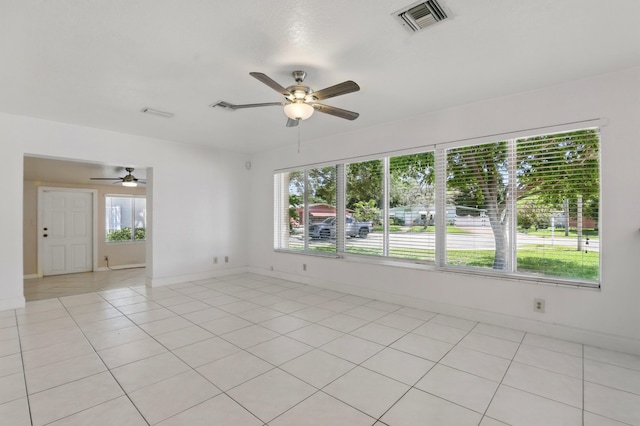 empty room featuring baseboards, a ceiling fan, and visible vents