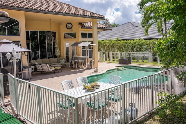 view of pool featuring a patio area, a bar, and an outdoor hangout area